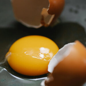 Huevo roto con yema de huevo y clara